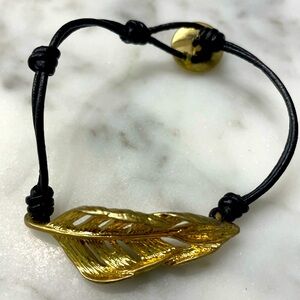 Chloe + Isabel brown leather string and gold color leaf and logo emblem bracelet